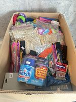 Top view of box showing detergent, microcassettes, skirts, plate hanger packages