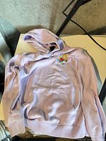 Front view of lavender Bart Simpson hoodie showing chest graphic, pocket and hood