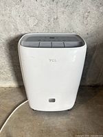 Front view of TCL DEA50E dehumidifier showing body, cord and wheels
