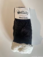 Front of packaged slipper socks showing brand logo and product