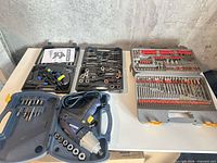 All three tool cases open showing impact wrench kit, tap and die set, and drill bit set