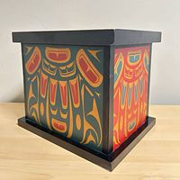 Three-quarter view of decorated wooden box showing side panels and base