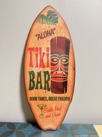Front view of surfboard wall sign showing full artwork and text