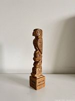 Front and side view showing eagle figure, animal carvings, and base text "Talking Stick" plus "then to be Understood"