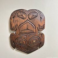 front view of carved wooden frog plaque