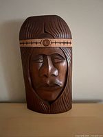 Front view of carved wood warrior mask showing overall design