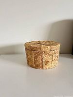 Side view of cylindrical wicker basket with lid