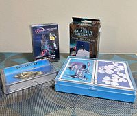 Four packages: Riviera shrink-wrapped deck, Alaska Cruise deck in box, Alcatraz deck in clear case, blue plastic double-deck case