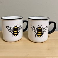 Two identical bee graphic mugs side by side