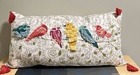 Front view of lumbar pillow showing full embroidery and tassels