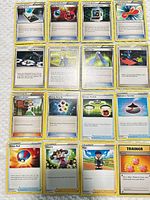 All 16 trainer/supporter/item cards laid out in 4×4 grid