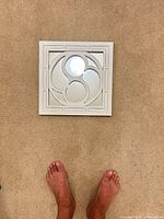 Front view of square white distressed wood wall mirror on carpet