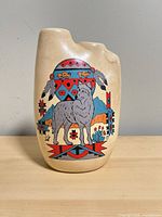 Front view of cream ceramic vase with wolf and Southwestern motif