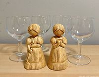 Two ceramic folk woman shakers and four clear wine glasses