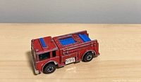 Left side view of red Hot Wheels Fire Eater fire truck showing blue roof insert and wheels
