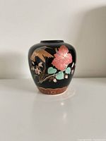 Front view of black porcelain vase with bird and floral design