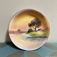 Front view of porcelain plate showing full hand-painted landscape scene