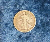 Obverse of 1943 Walking Liberty half dollar on blue fabric
