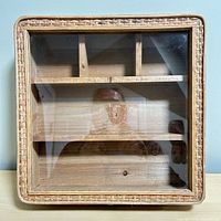 Top view showing overall square display box with wicker trim and glass lid