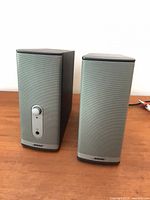 Front view of both Bose speakers showing grille, control pod and logo