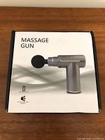 Box cover showing image and wording Massage Gun