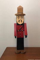 full front view of wooden Mountie figurine standing on table