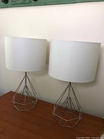 Both chrome wire base lamps with shades on tabletop
