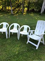 Group shot of three chairs and one lounger on grass