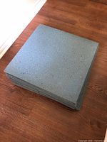 Stack of blue speckled rubber tiles on wood floor