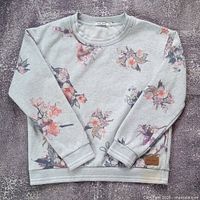 Front view of grey floral Obey crewneck showing full design and leather patch