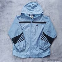 Full front view of light blue adidas hooded windbreaker