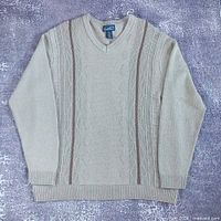 Front view of beige Arnold Palmer V-neck sweater with brown stripes