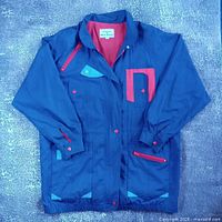 Front view of jacket showing color blocks and red zipper