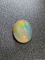 Opal on textured black surface showing play-of-color