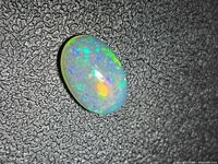 Front view of oval opal displaying pinfire colors