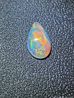 Front view of pear opal showing red, orange and green flashes