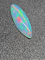 Marquise Ethiopian opal showing multicolour play of colour on textured background
