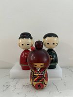 Front view of three Kokeshi dolls