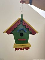 Front view showing entire painted birdhouse and hanging wire
