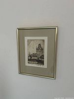 Framed etching hanging on wall
