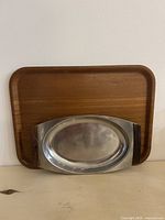 Both trays upright against wall showing front surfaces and size relationship