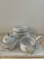 group shot of sugar bowl, handled mug, two floral bowls