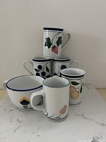 Group shot of all six Dansk porcelain mugs and latte bowl