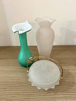 All three vintage glass pieces grouped on wooden surface