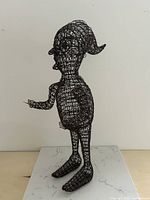 Front three-quarter view of entire wire mesh elf sculpture