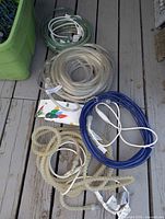 Coiled clear, blue and green rope lights on deck with power cords visible
