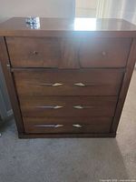 Front view of wood dresser showing four drawers and hardware
