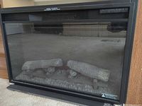 Front view of Spectrafire electric fireplace insert with glass panel and log set