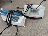 Two corded steam irons, Black+Decker Light’n Easy and Permatech, side by side
