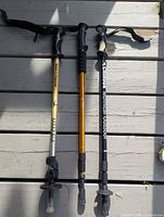 Three mismatched trekking poles laid side-by-side